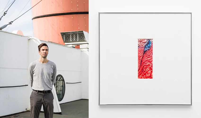 side by side images, on the left a man in casual clothes aboard a ship facing the viewer, and on the right a framed vertical print of a detail of a bird's beak